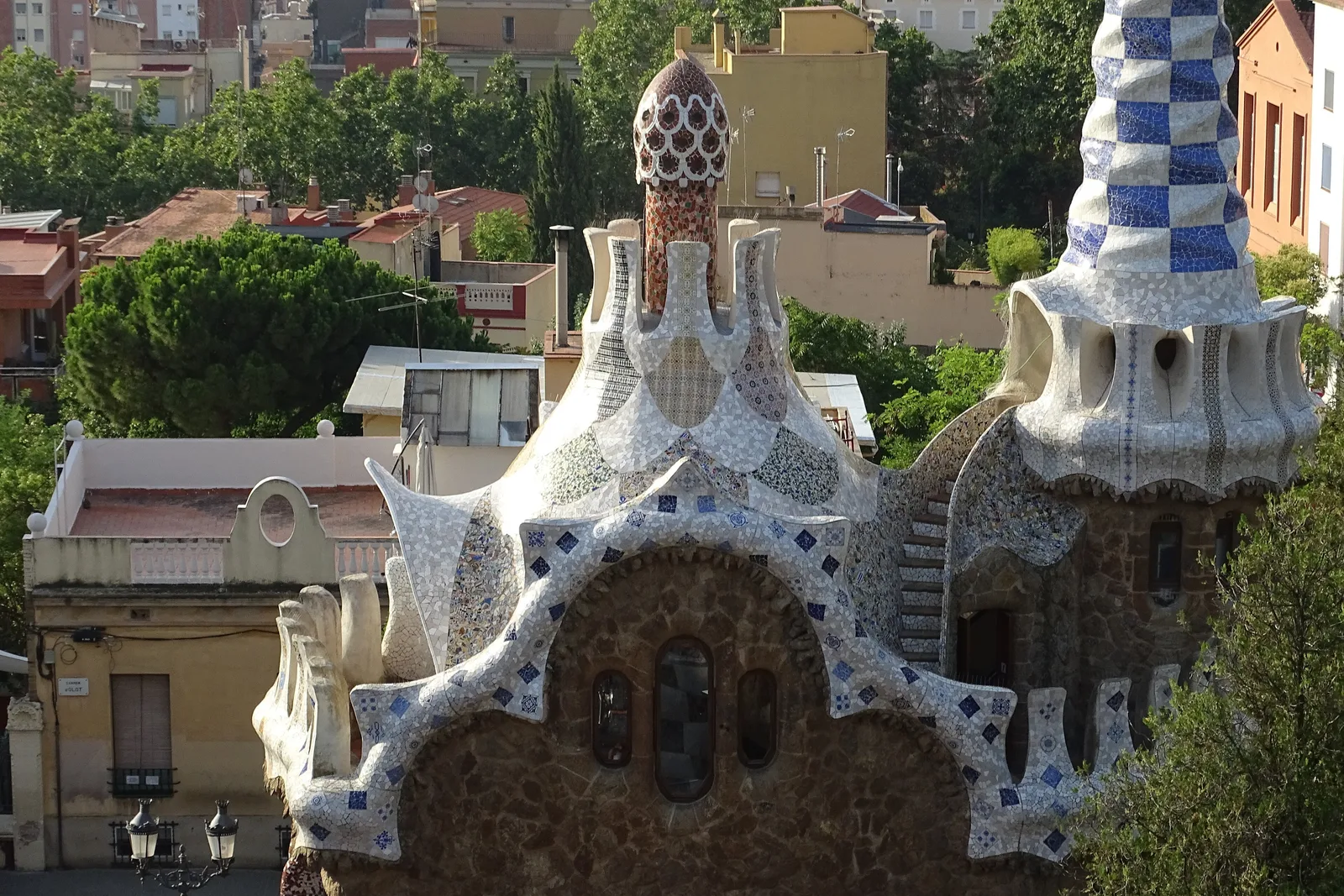 Gaudí's entrance pavilions at Park Güell rise above a stone wall in Barcelona